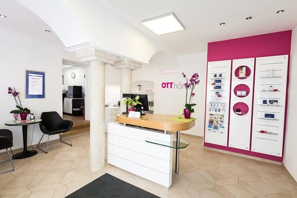 Modern eingerichteter Empfangsbereich eines Hörakustik-Fachgeschäfts mit Beratungstheke.